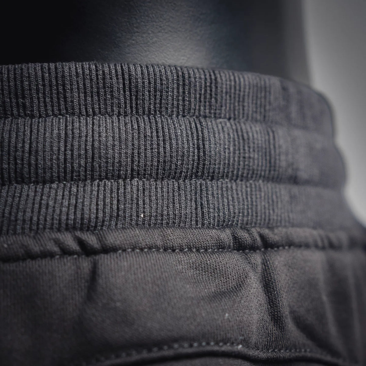 Black Stone Island pants elastic waistband and stitched seam close-up