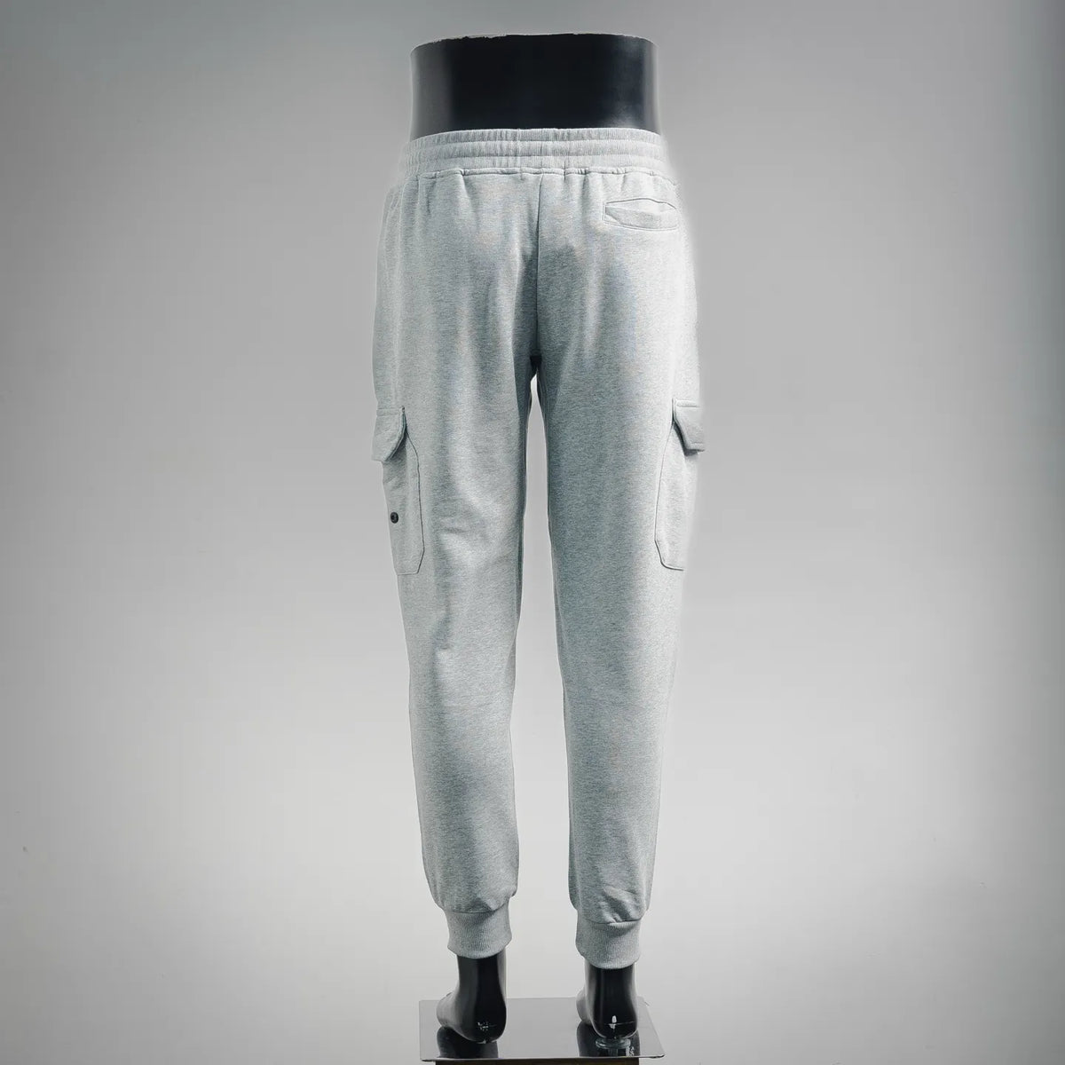 Light gray jogger pants on mannequin with rear cargo pockets and elastic cuffs