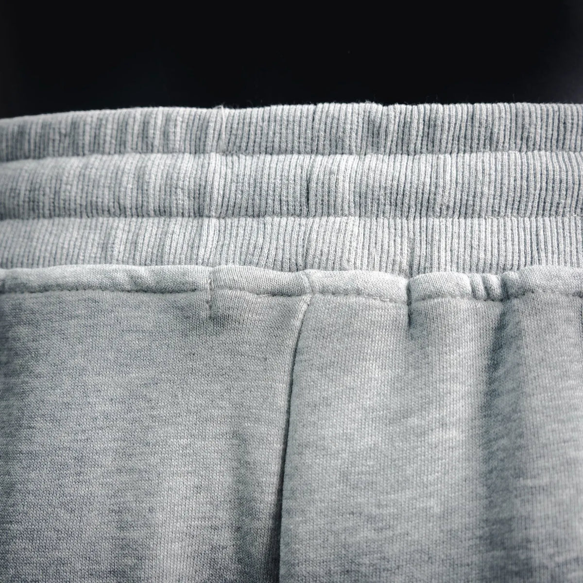 Light gray elastic waistband and side seam stitching on jogger pants