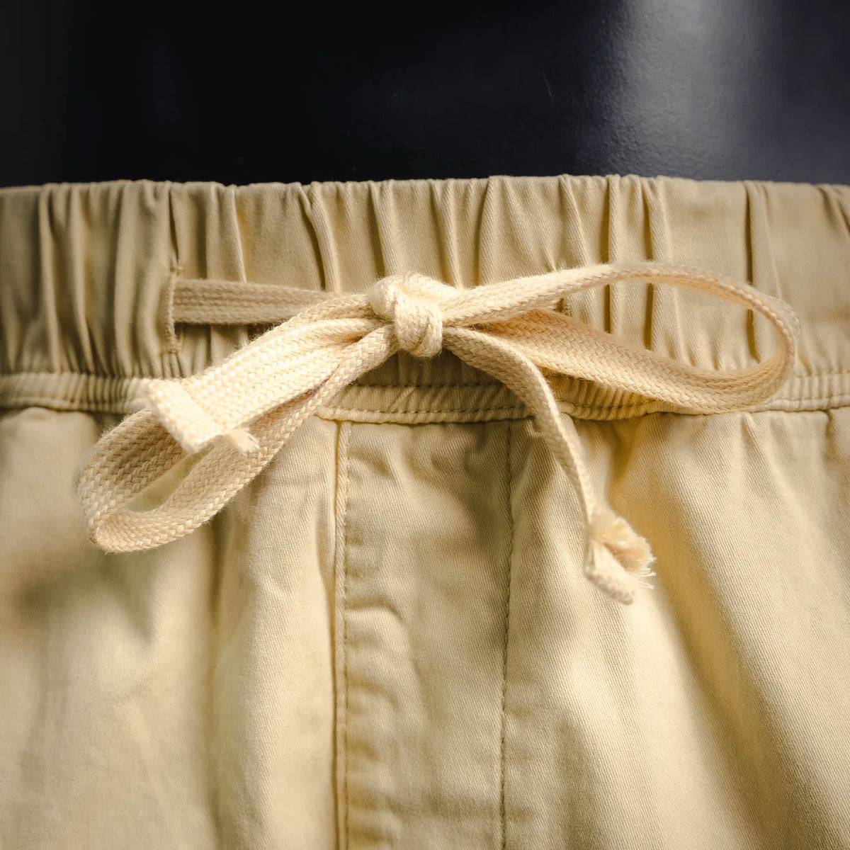 Beige drawstring waist with knotted cord and elastic waistband