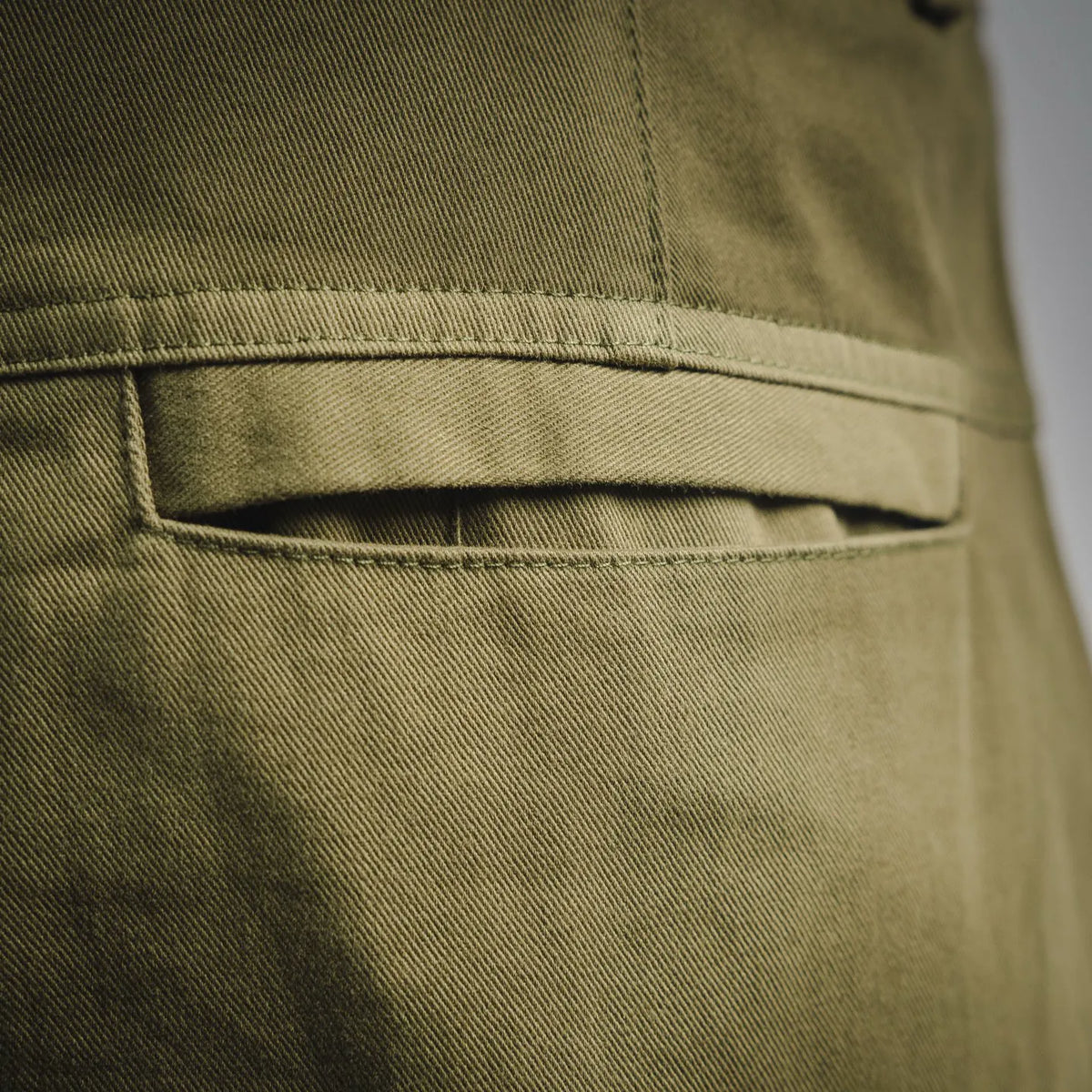Olive cargo shorts pocket flap with stitched trim and inset panel