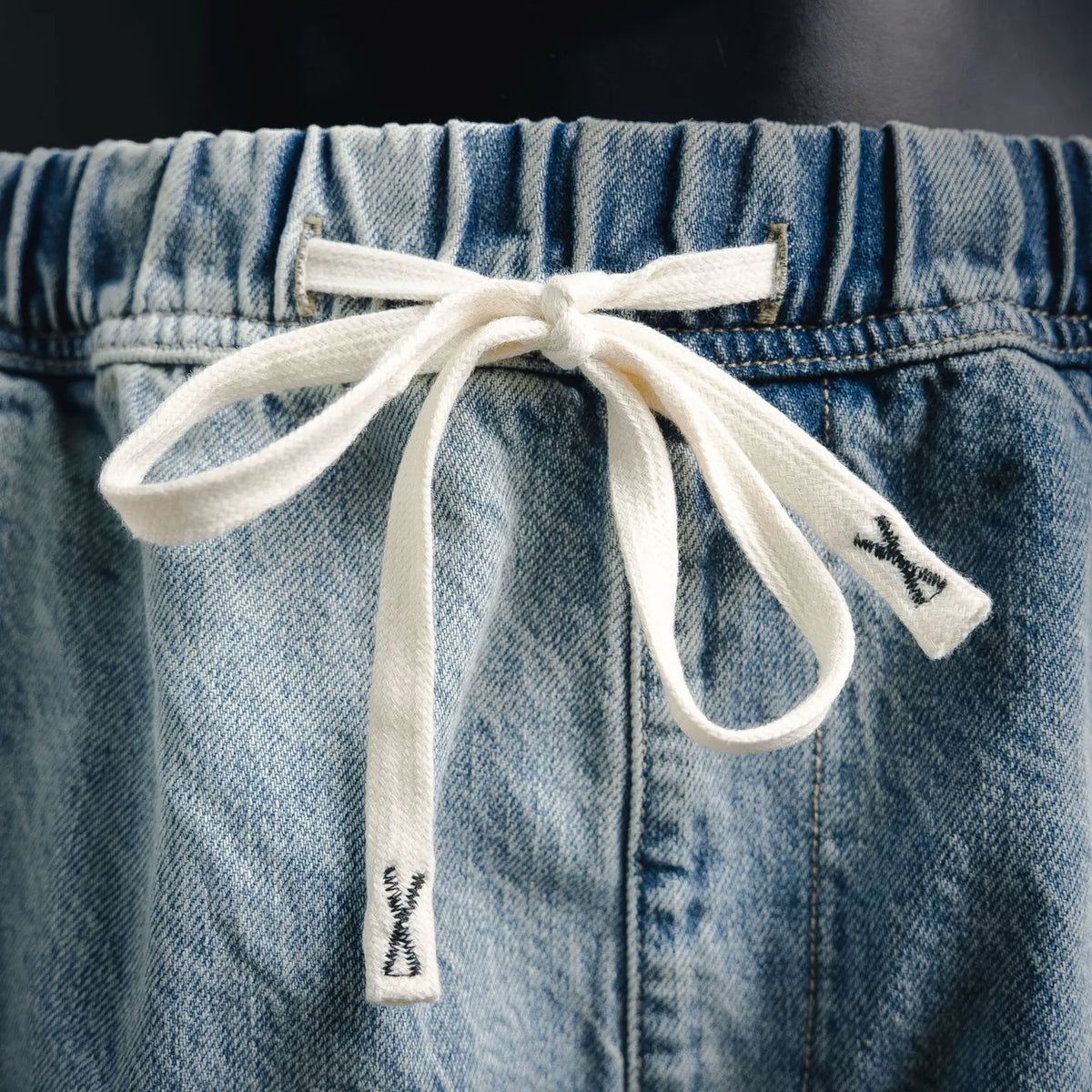 Light blue denim shorts with elastic waist and white drawstring bow