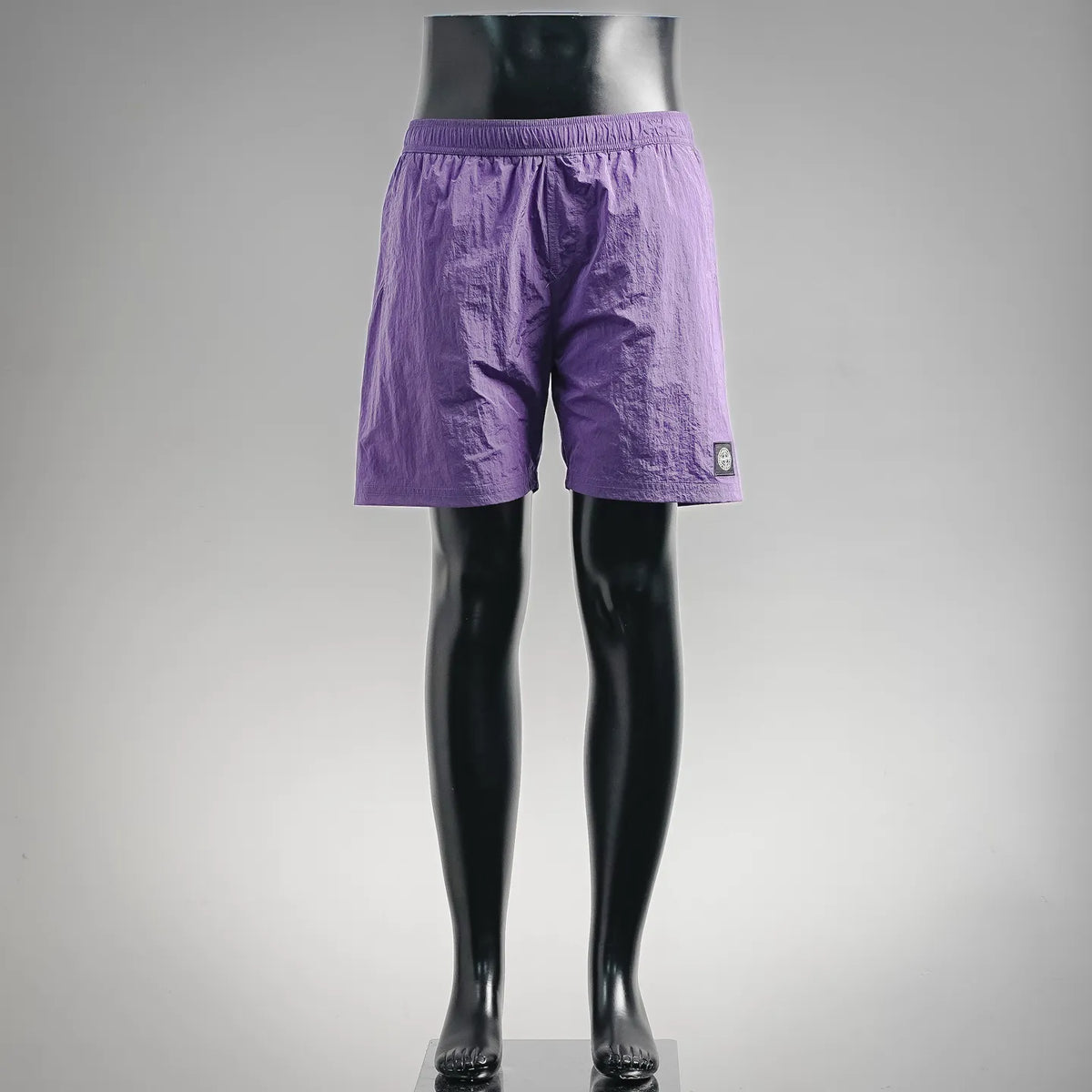 Purple Stone Island shorts with elastic waistband and small logo patch on side.