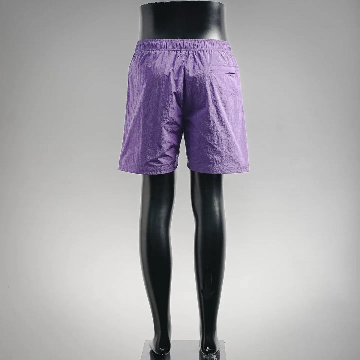 Purple Stone Island shorts on mannequin, with elastic waistband and side logo detail.