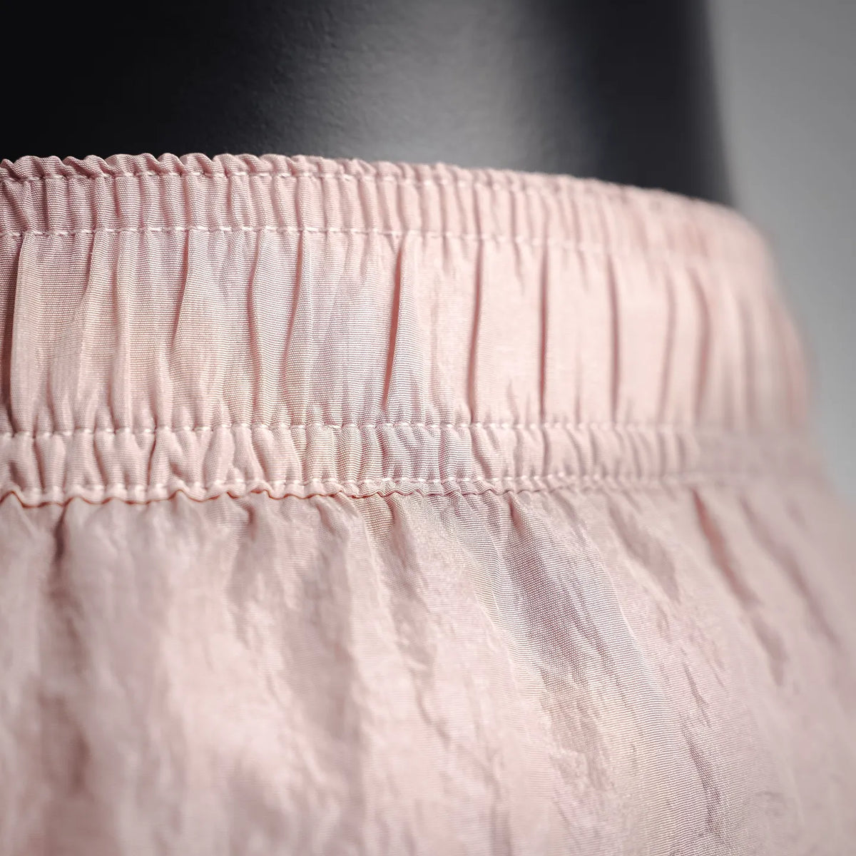 Light pink shorts waistband with gathered elastic and stitched seam