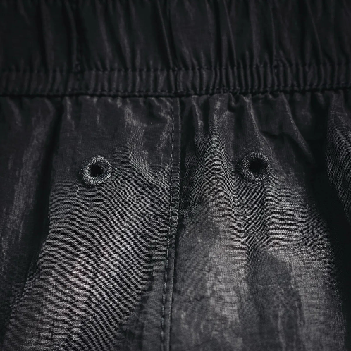 Black pants with elastic waistband and stitched front pocket openings