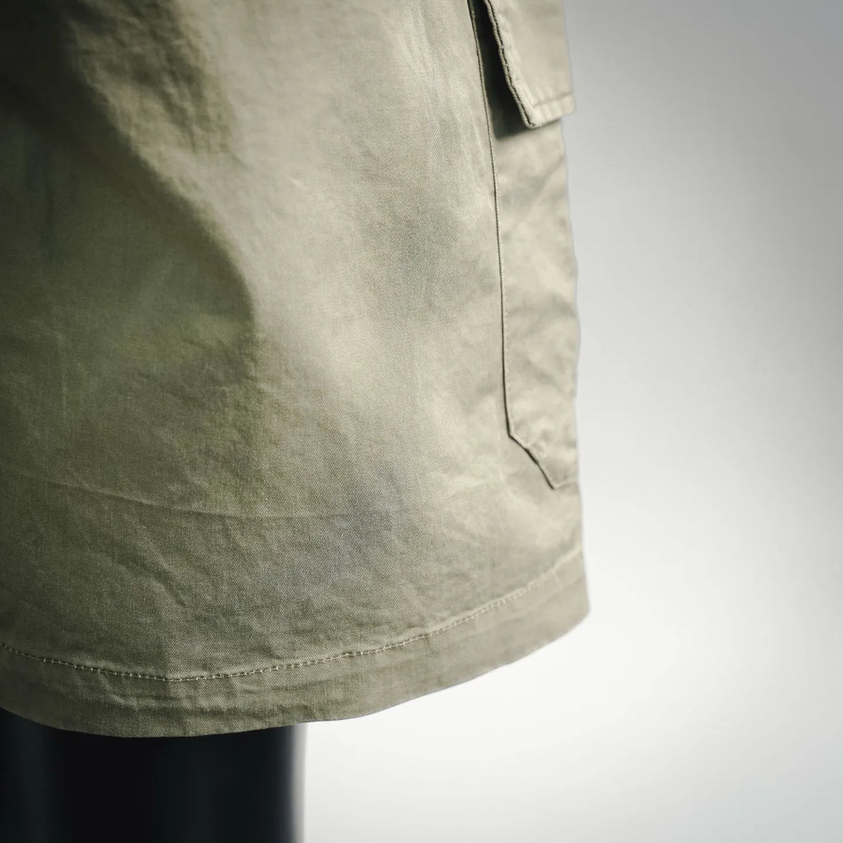 Olive cargo shorts front pocket seam and fabric hem