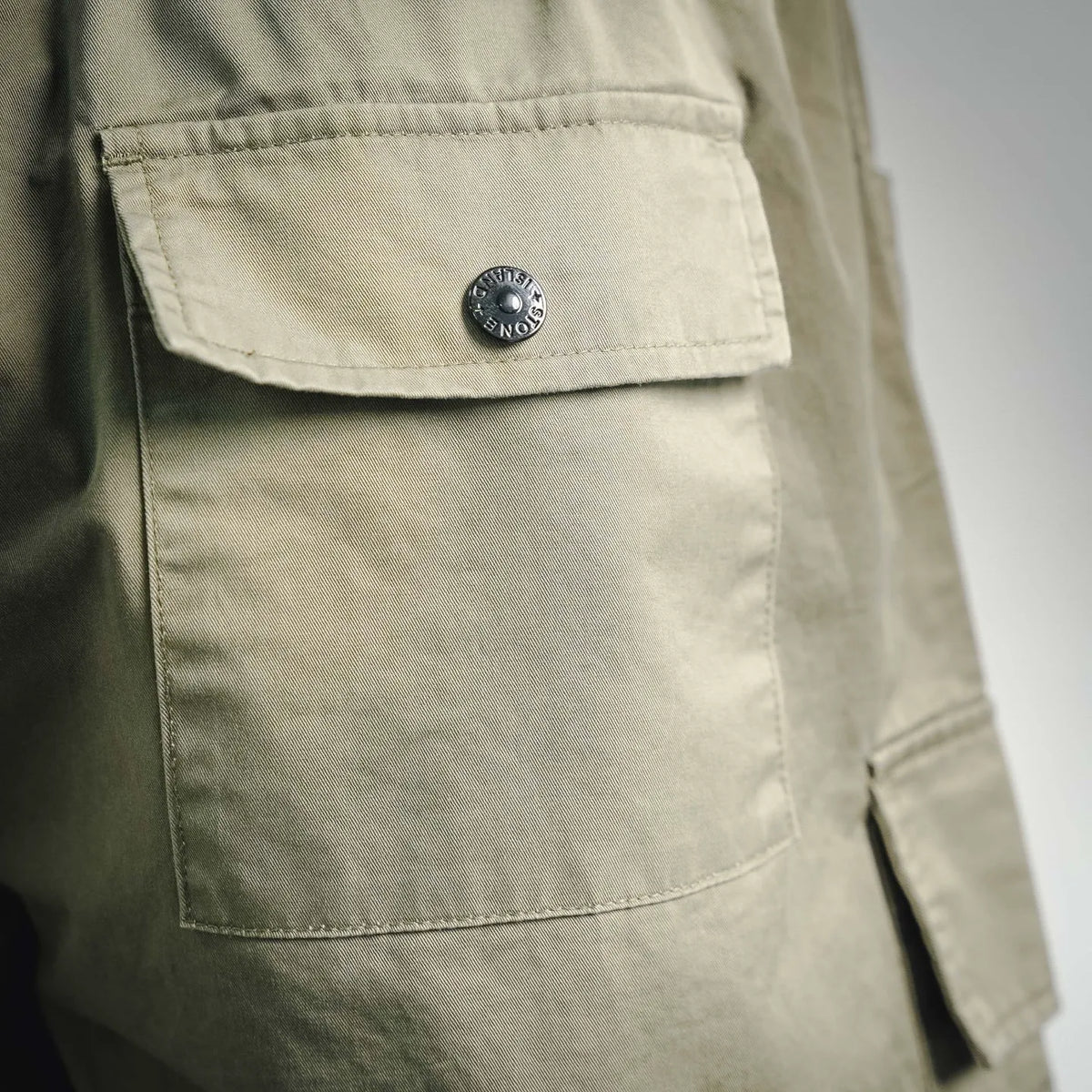 Olive cargo shorts with square flap pocket and metal snap button