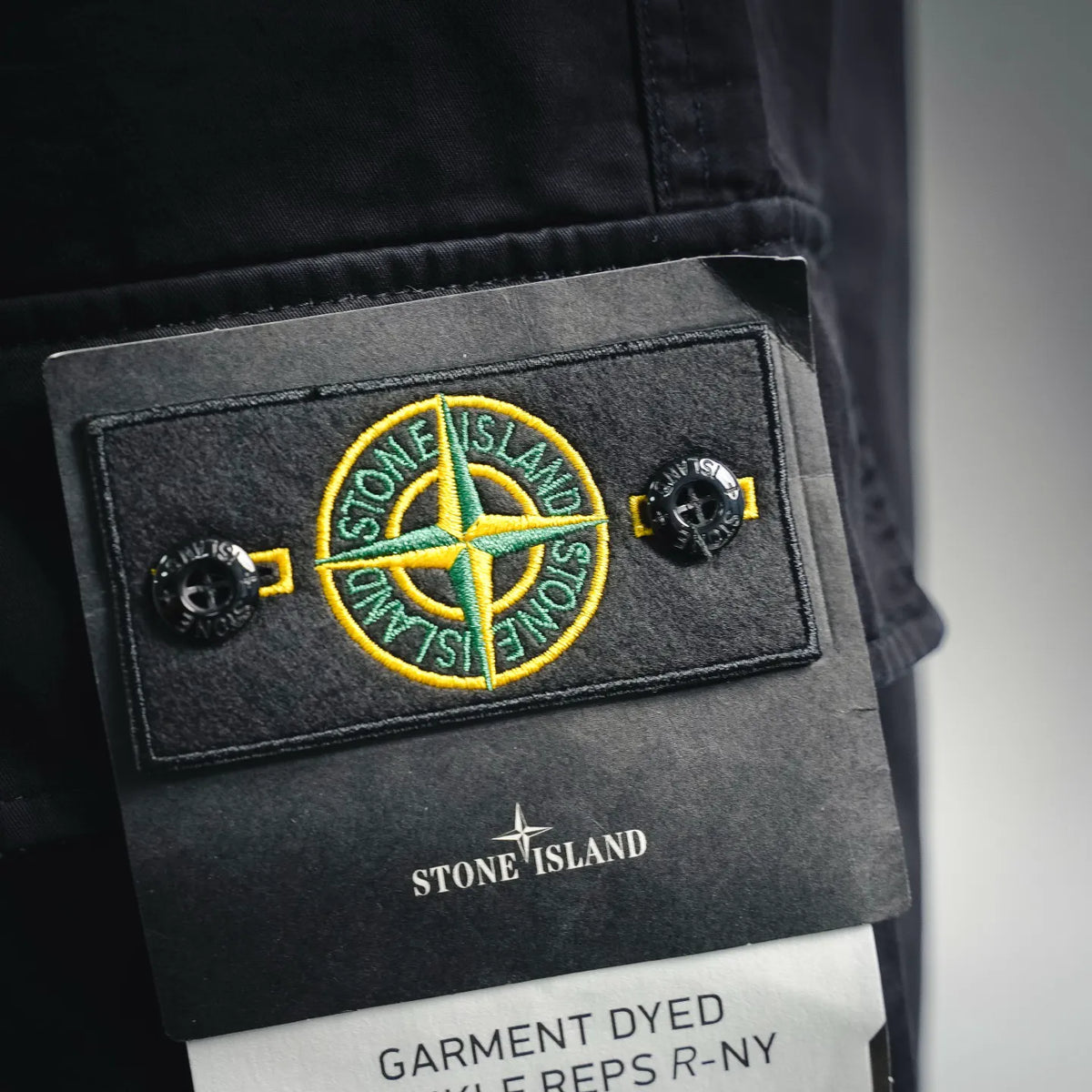 Stone Island patch label on black shorts; GARMET DYED REPS R-NY