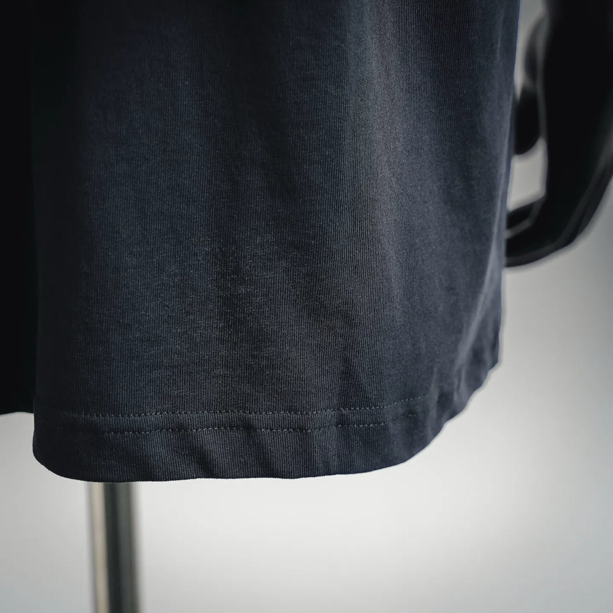 Stone Island short-sleeve T-shirt hem close-up, dark navy knit finish
