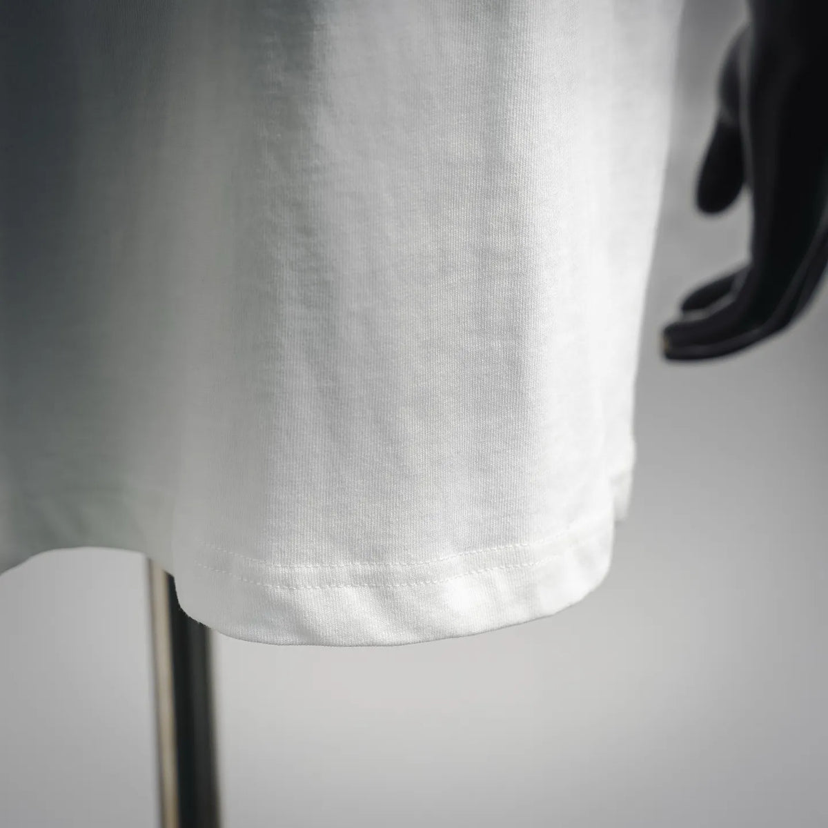 Stone Island short-sleeve T-shirt hem detail, white fabric with straight stitched bottom