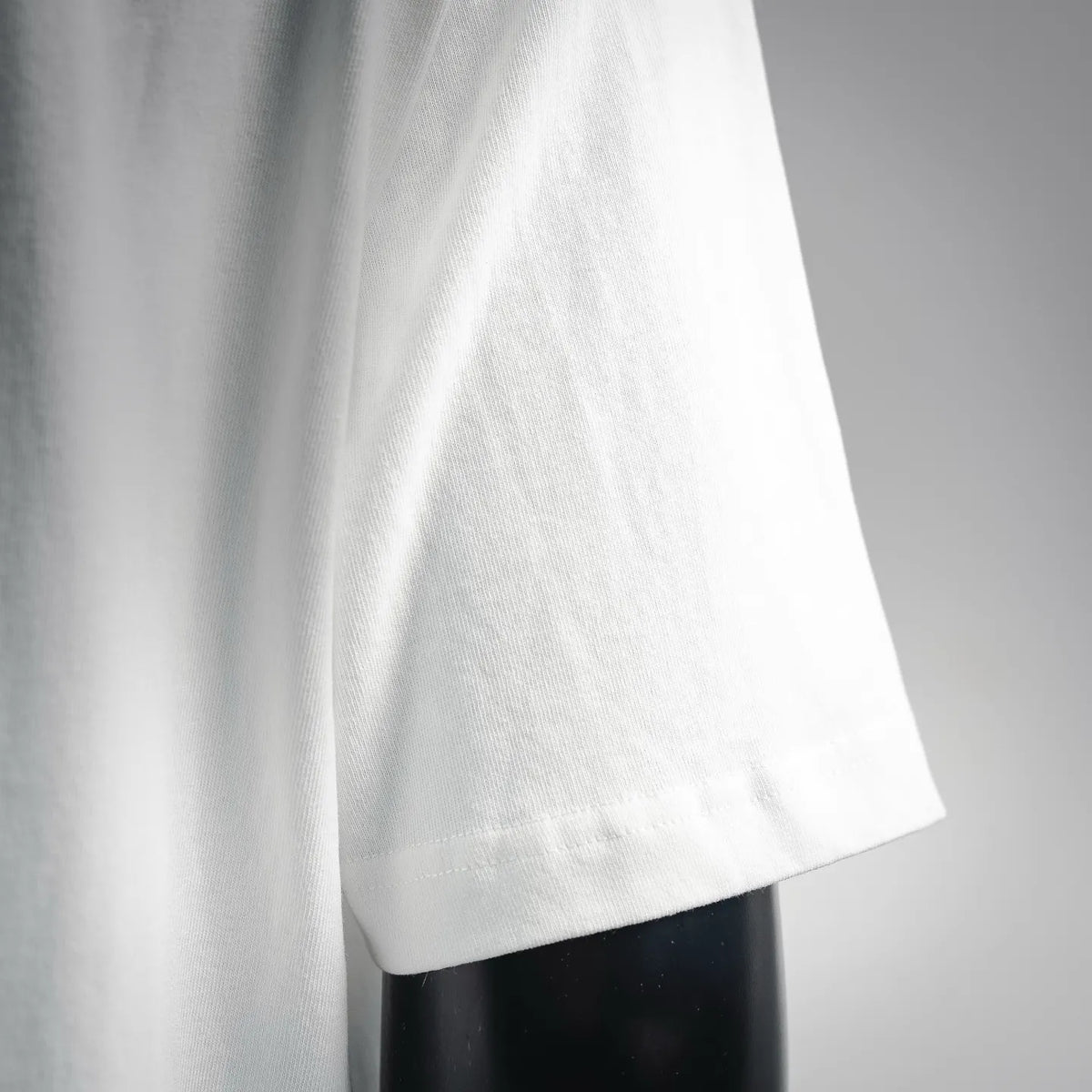 Stone Island short-sleeve T-shirt side view, white fabric with curved hem stitching