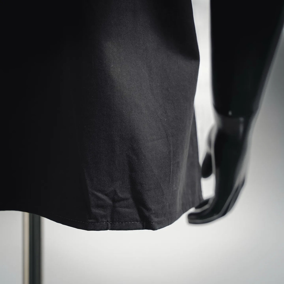Black short-sleeve shirt hem and cuff area with visible stitching
