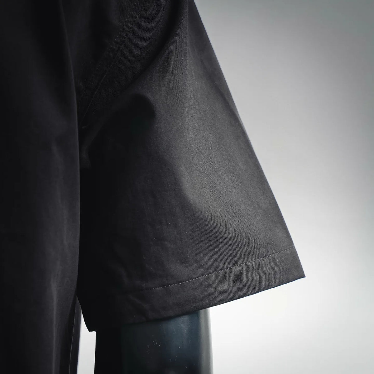 Black short-sleeve shirt sleeve cuff with curved hem and stitched detail