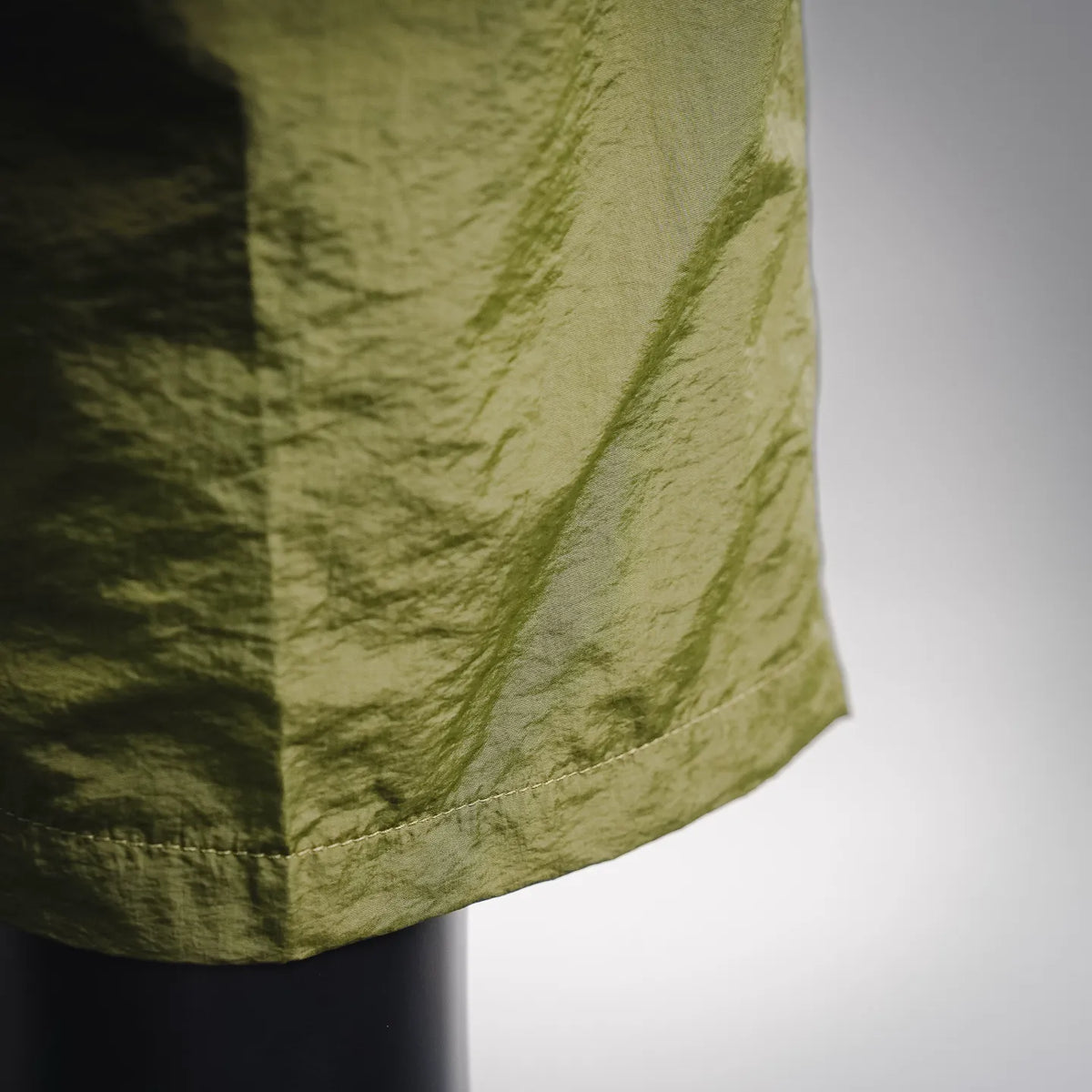Olive green shorts fabric with curved side seam and hem stitching detail