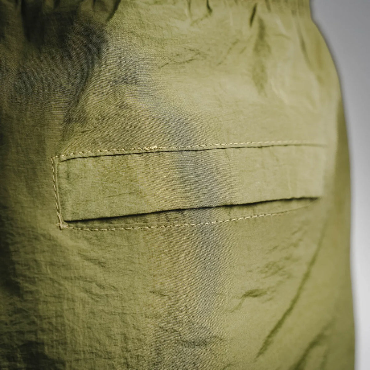Olive green cargo-style shorts pocket with topstitched edge