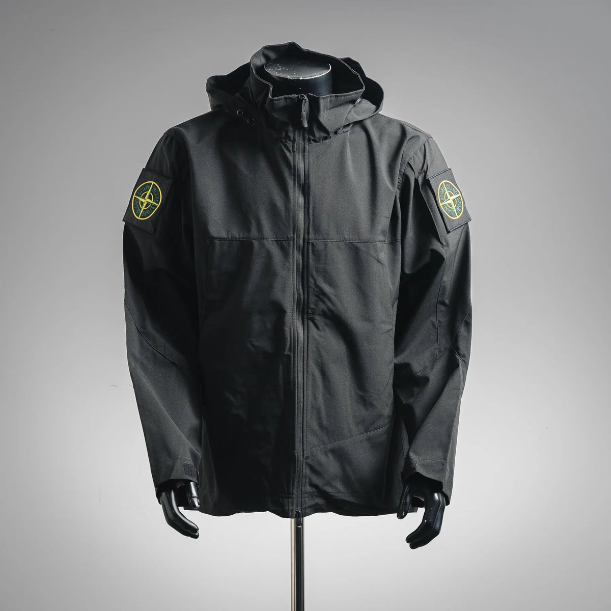 Stone Island hooded coat in dark charcoal with full front zipper and round sleeve logo