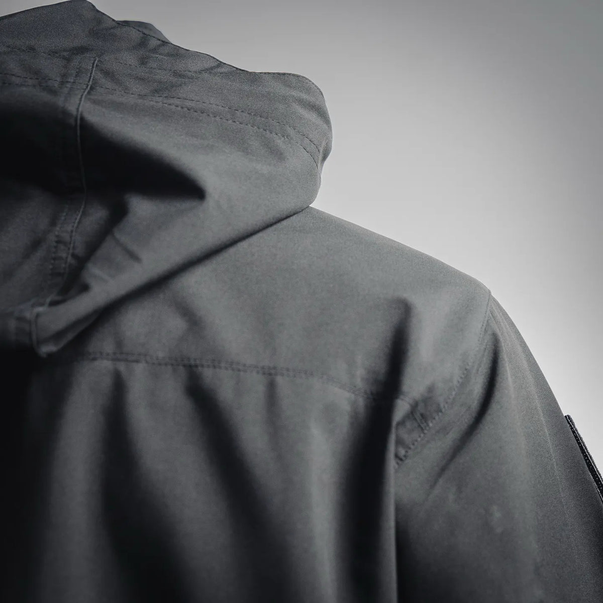 Dark charcoal hooded coat with seam detailing and inner hood lining at shoulder