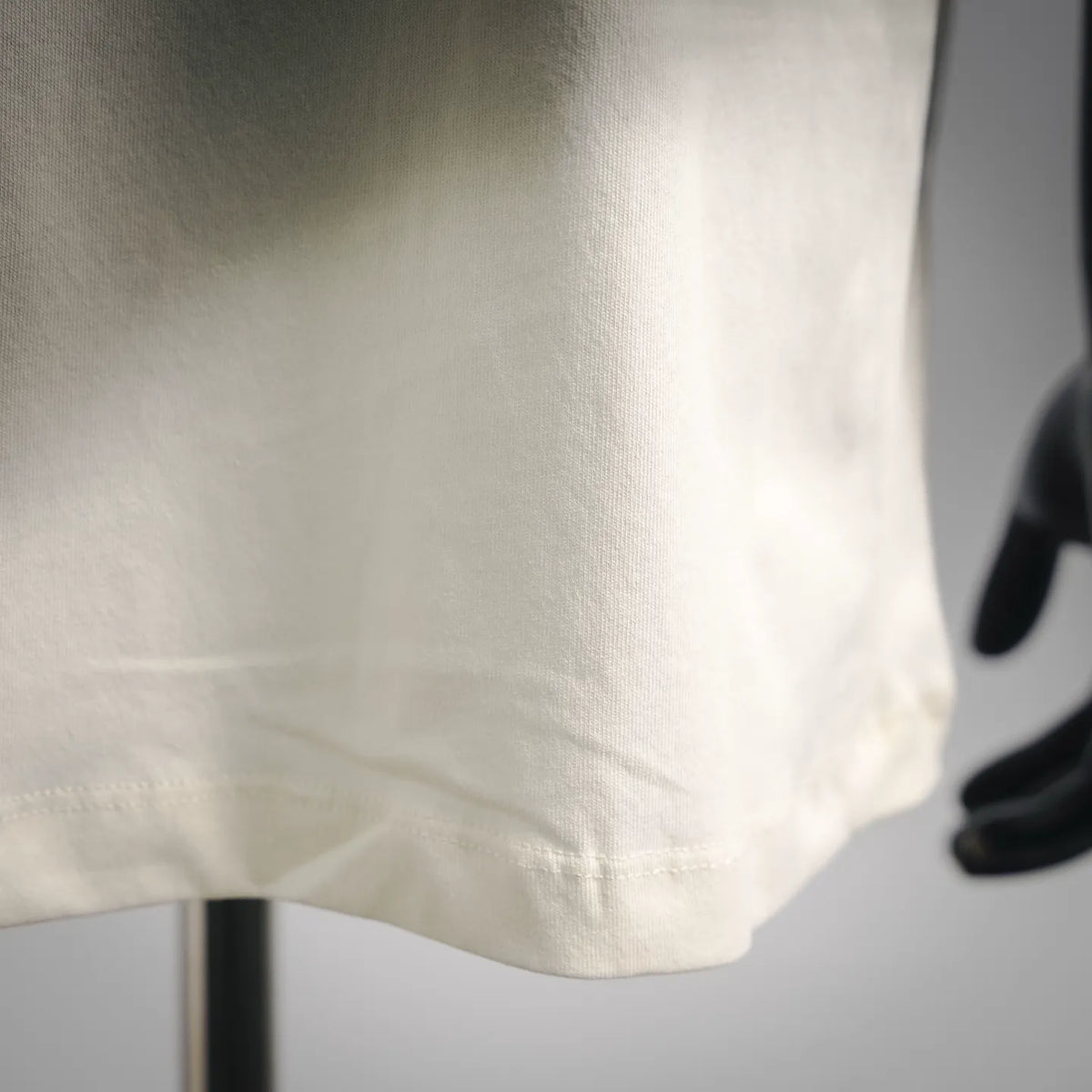 Stone Island short-sleeve T-shirt, light cream, close-up of lower front hem