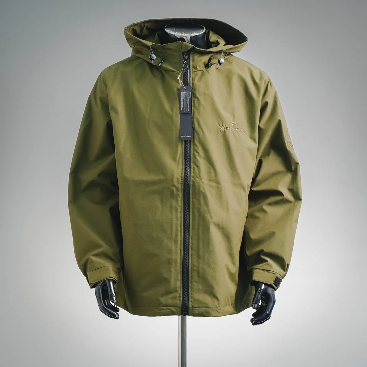 Olive green hooded zip-up coat with front zipper and snap collar tabs