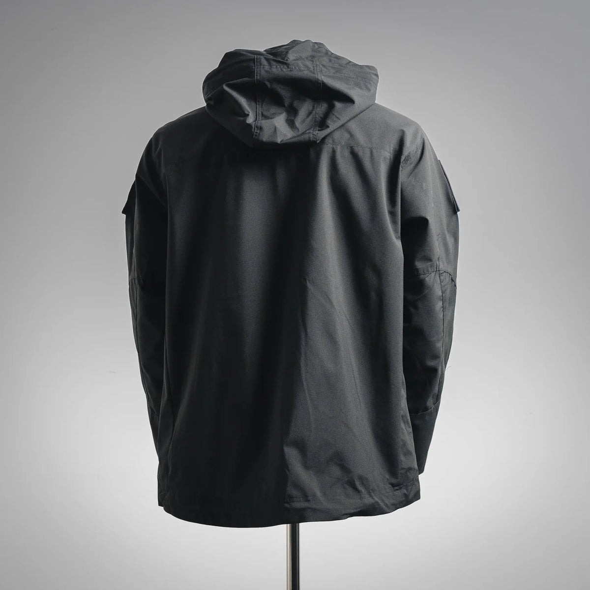 Stone Island hooded coat back view, dark fabric with hood detail.