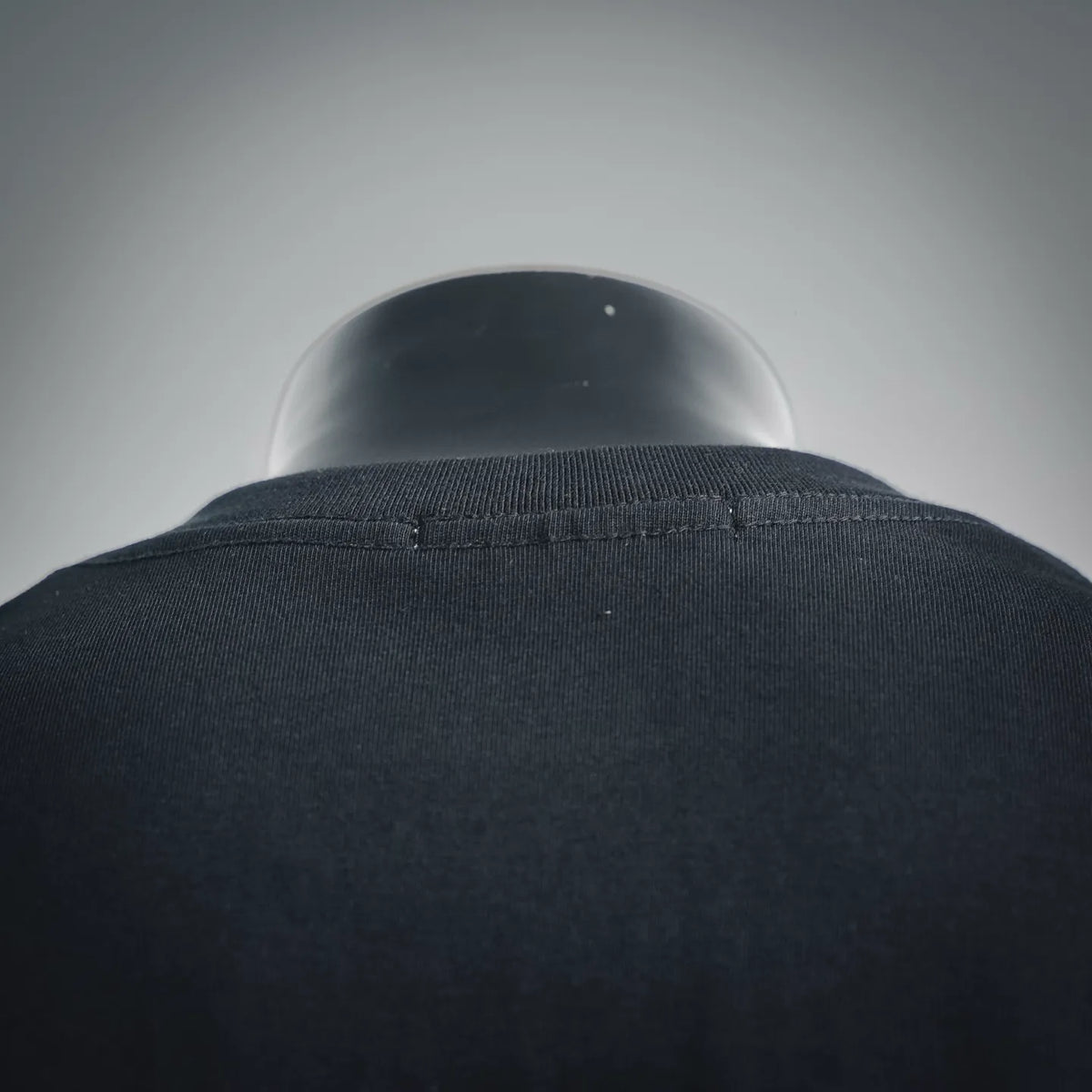 Black T-shirt crewneck collar ribbing detail, close-up