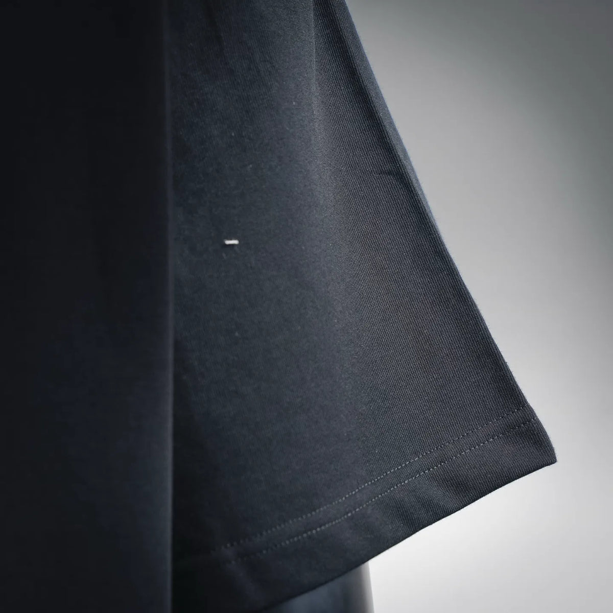 Black short-sleeve T-shirt sleeve cuff edge detail, close-up