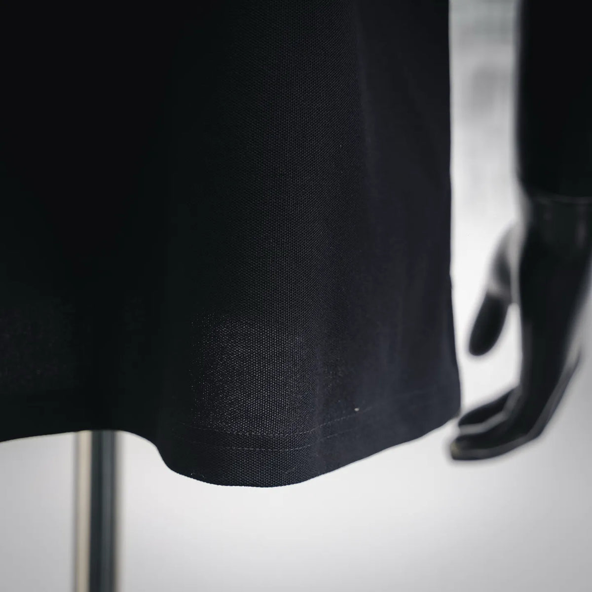 Stone Island polo shirt hem and fabric texture close-up, dark navy/black