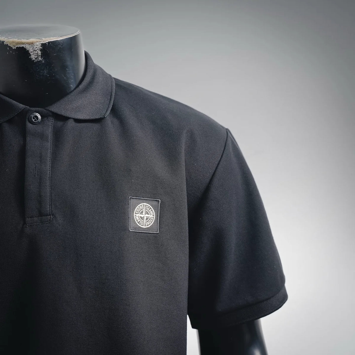 Stone Island polo shirt chest area with embroidered shield logo, dark navy/black