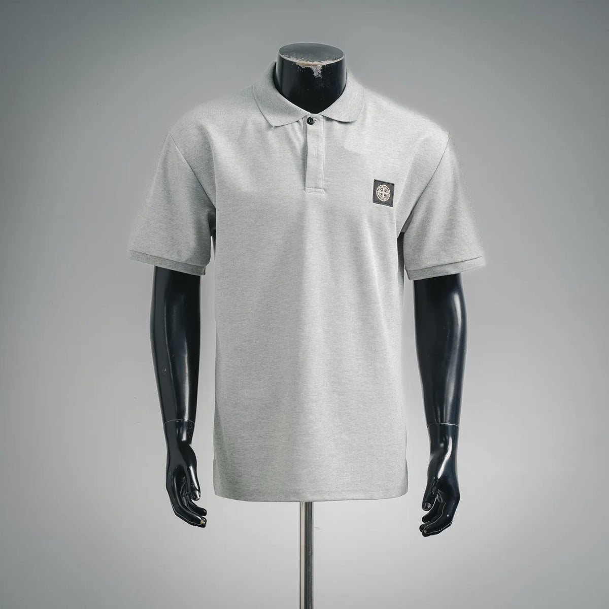 Light gray short-sleeve polo shirt with button placket and small chest logo patch