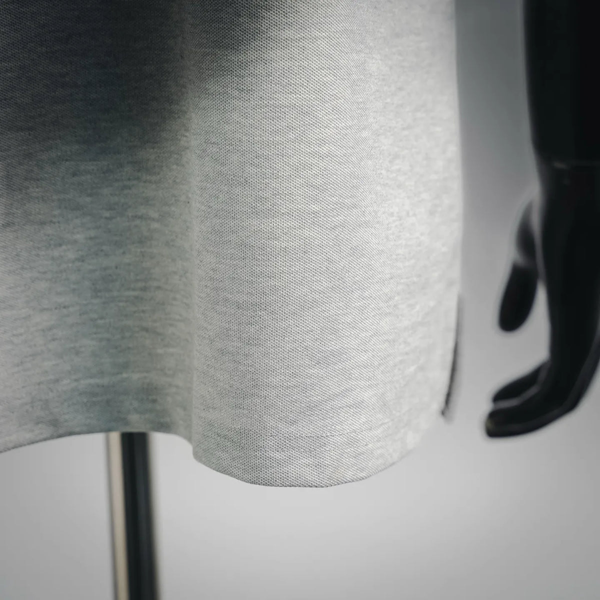 Light gray polo shirt fabric close-up with fine textured knit surface