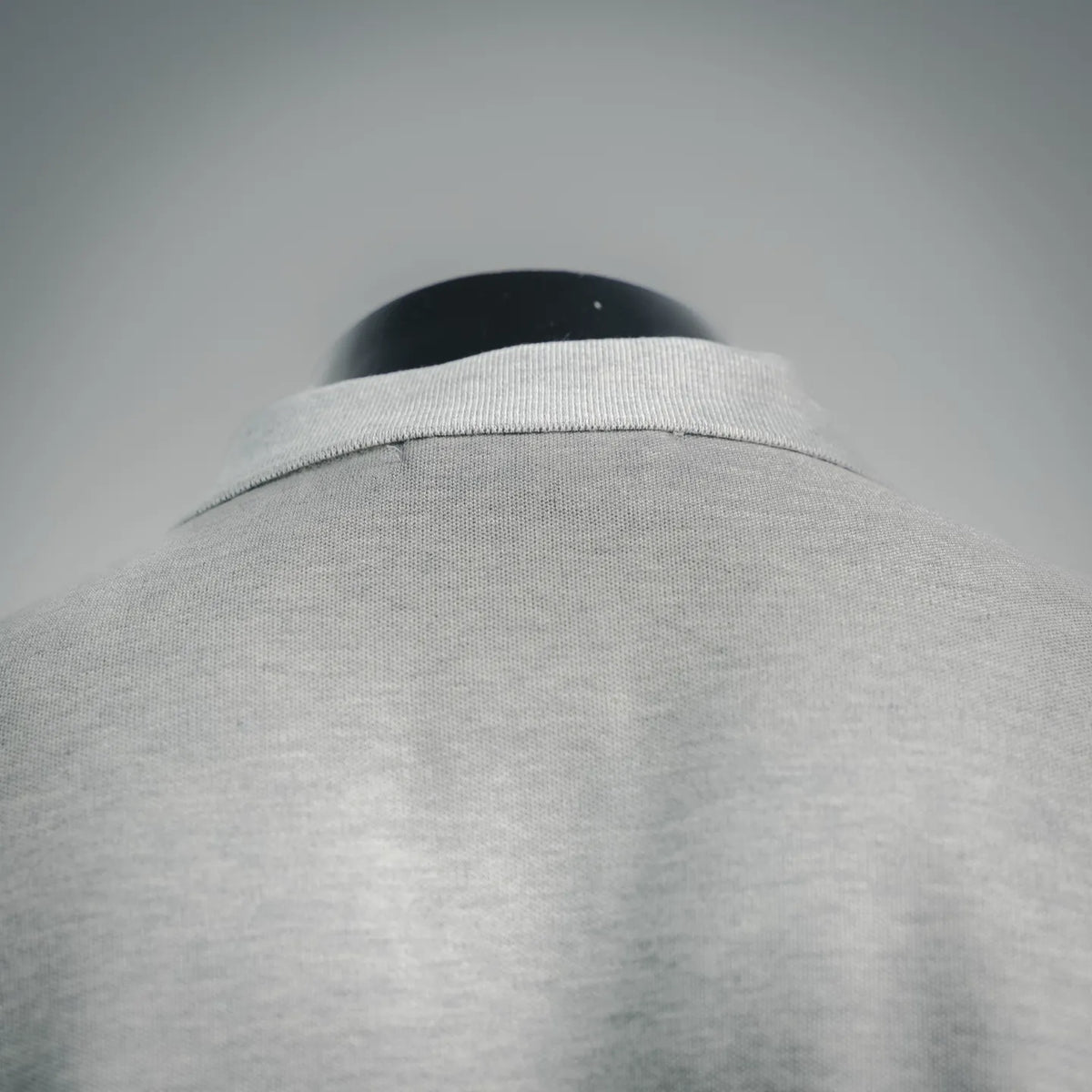 Light gray polo shirt collar and upper back seam view on mannequin