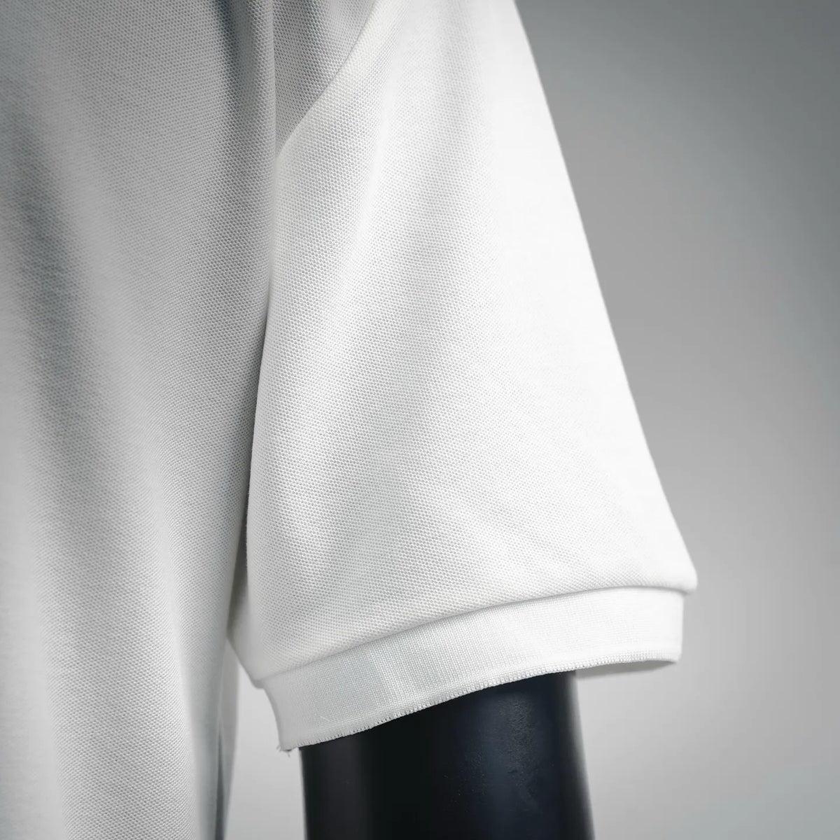 White polo shirt sleeve with ribbed cuff and clean side seam