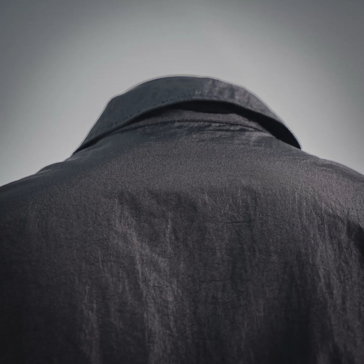 Stone Island dark coat jacket collar and yoke close-up with smooth textured fabric.