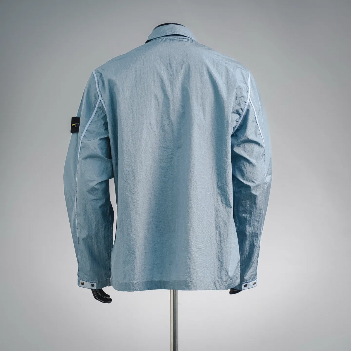 Light blue Stone Island coat back view with stand collar and side pocket