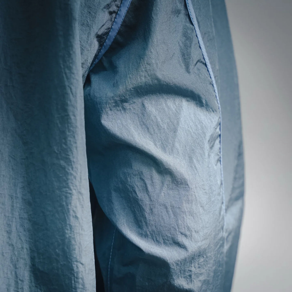 Light blue coat fabric close-up with seam panel and stitched detail