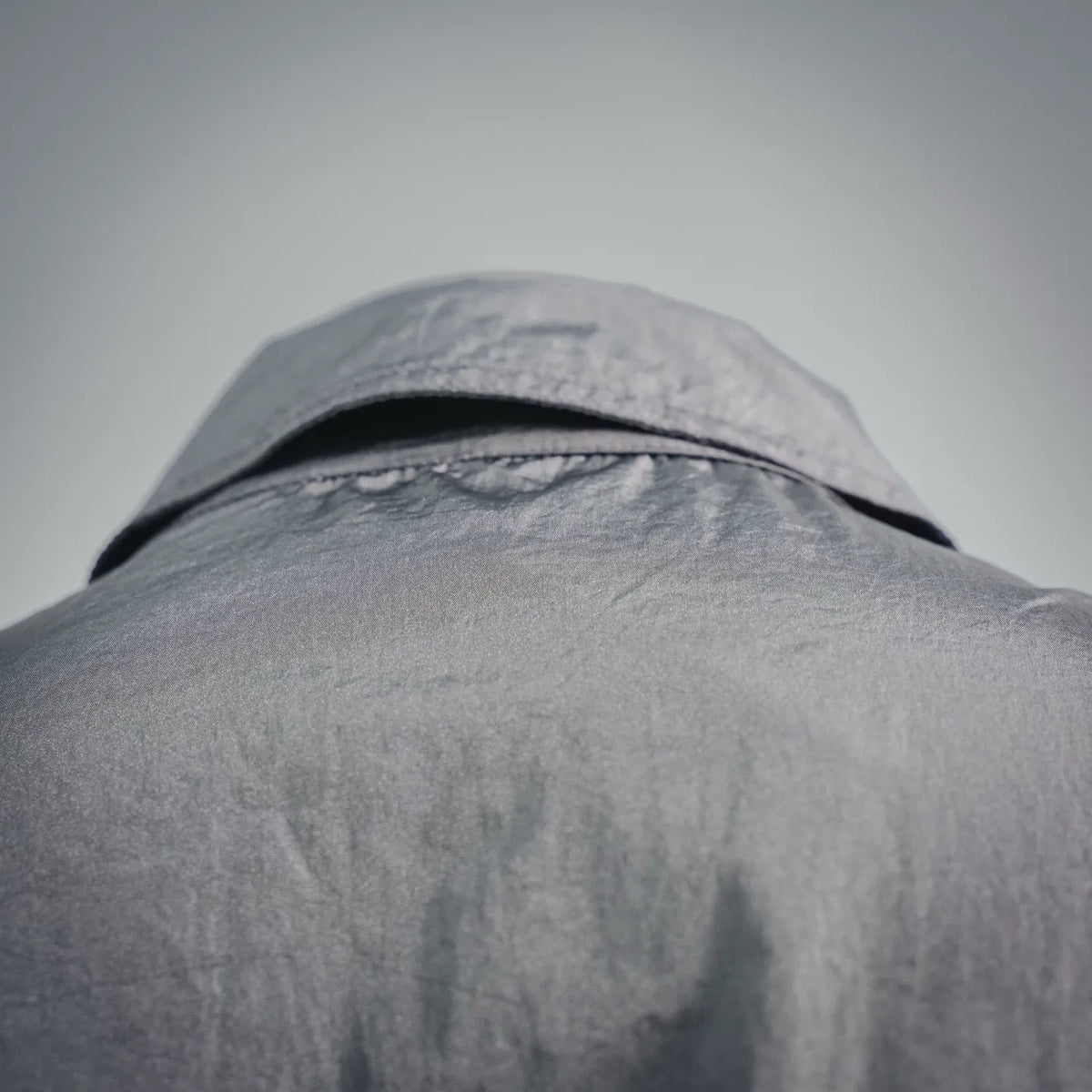 Stone Island coat collar and shoulder close-up in gray with curved neckline