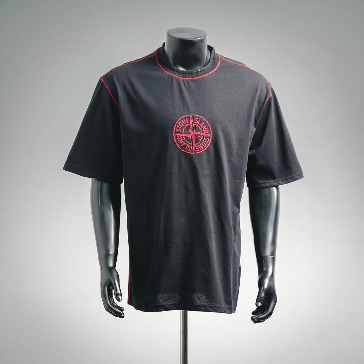 Black T-shirt with red crew-neck trim and circular Stone Island chest logo