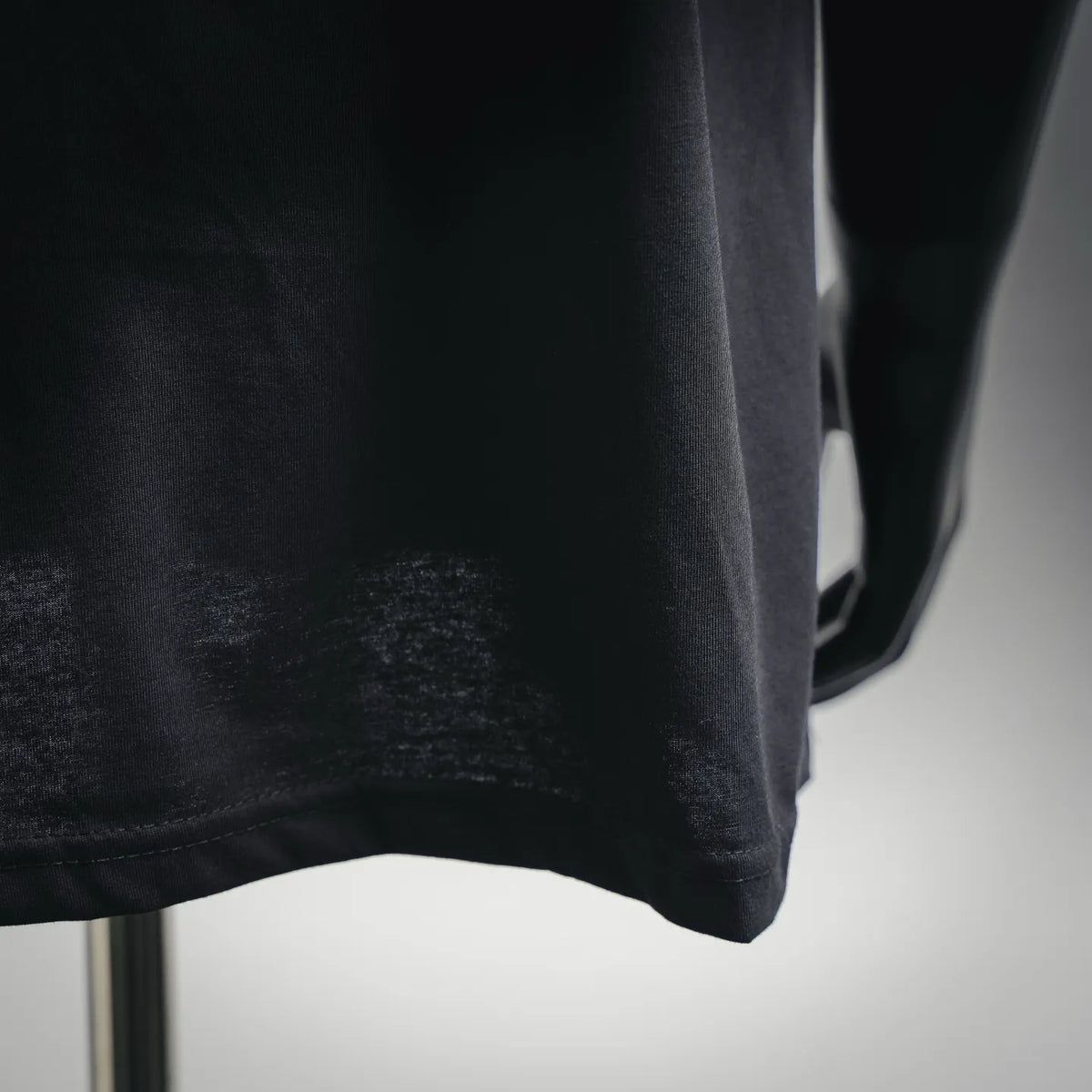 Black T-shirt fabric close-up with straight hem