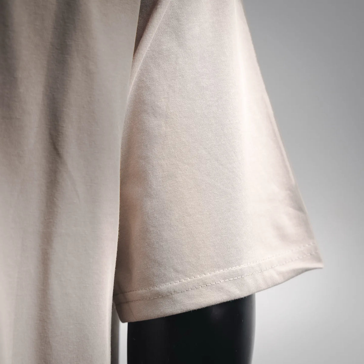 Light beige T-shirt side seam and stitched bottom hem