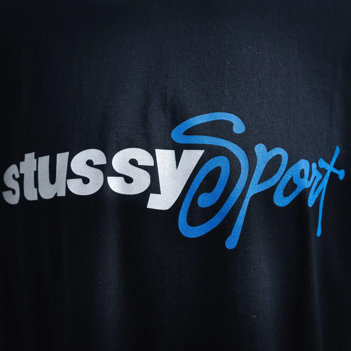 Front graphic print with Stussy Sport lettering in white and blue on black