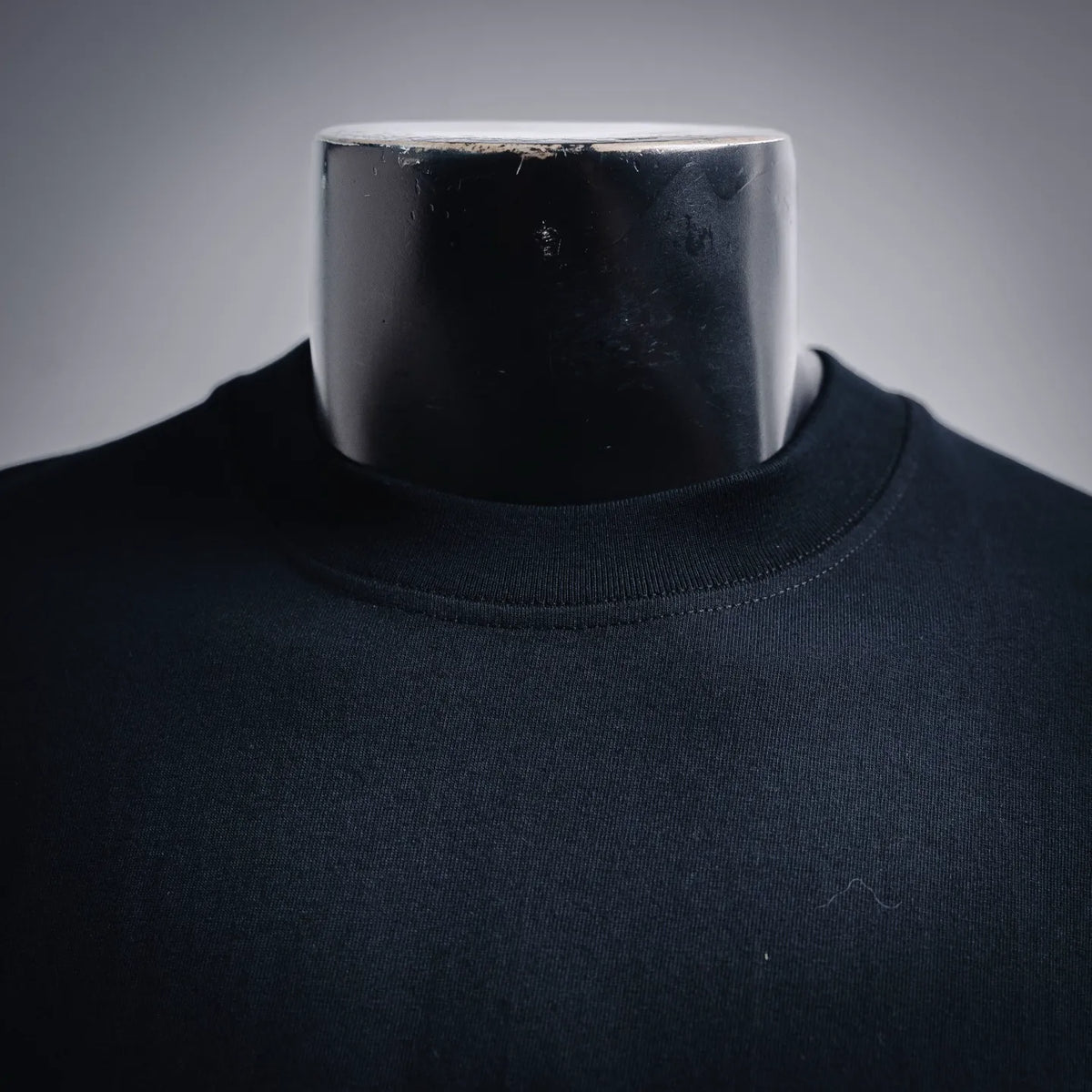 Black crew-neck T-shirt neckline view on a mannequin