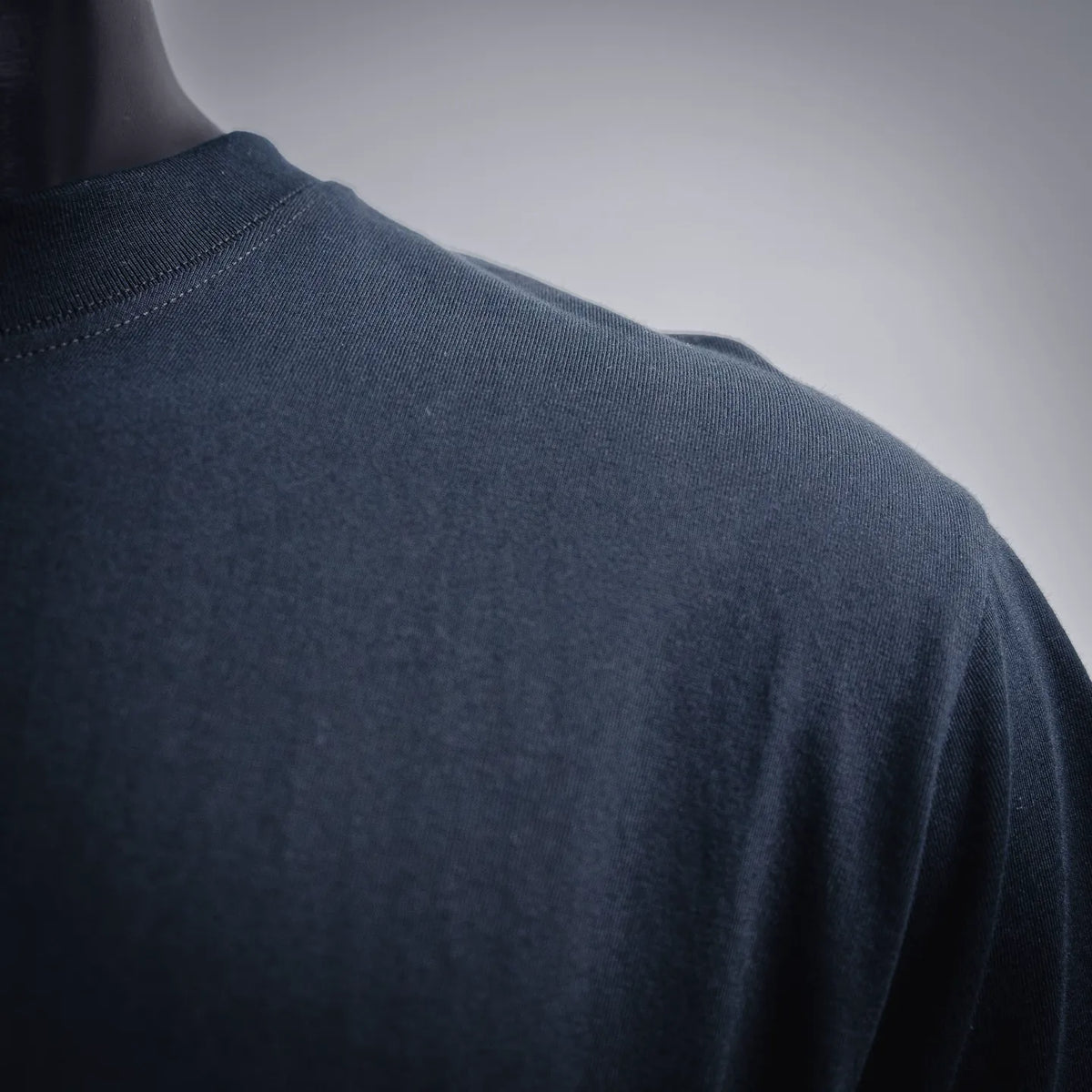 Stussy dark navy T-shirt back view with smooth fabric and stitched hem