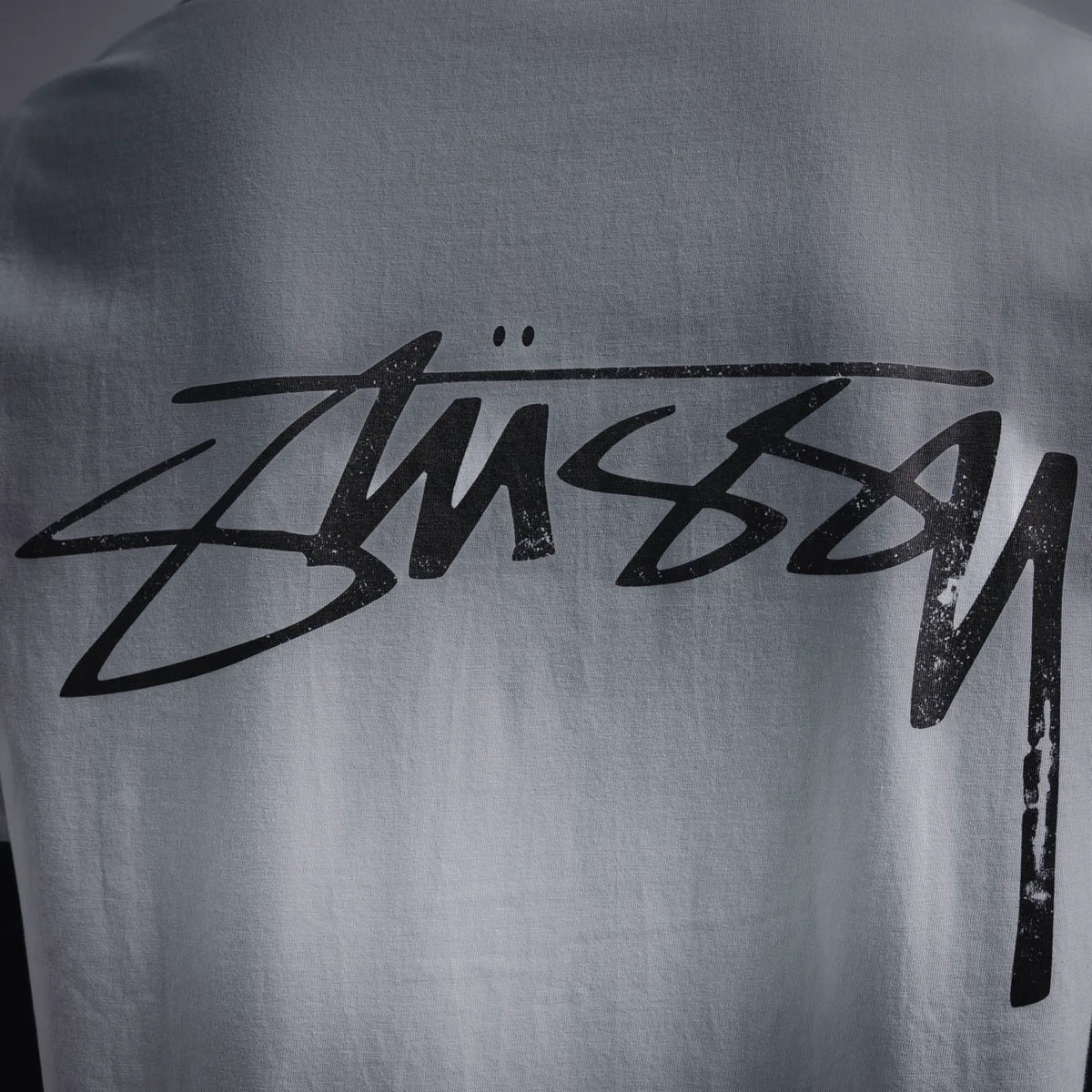 White T-shirt back: black Stussy script logo graphic