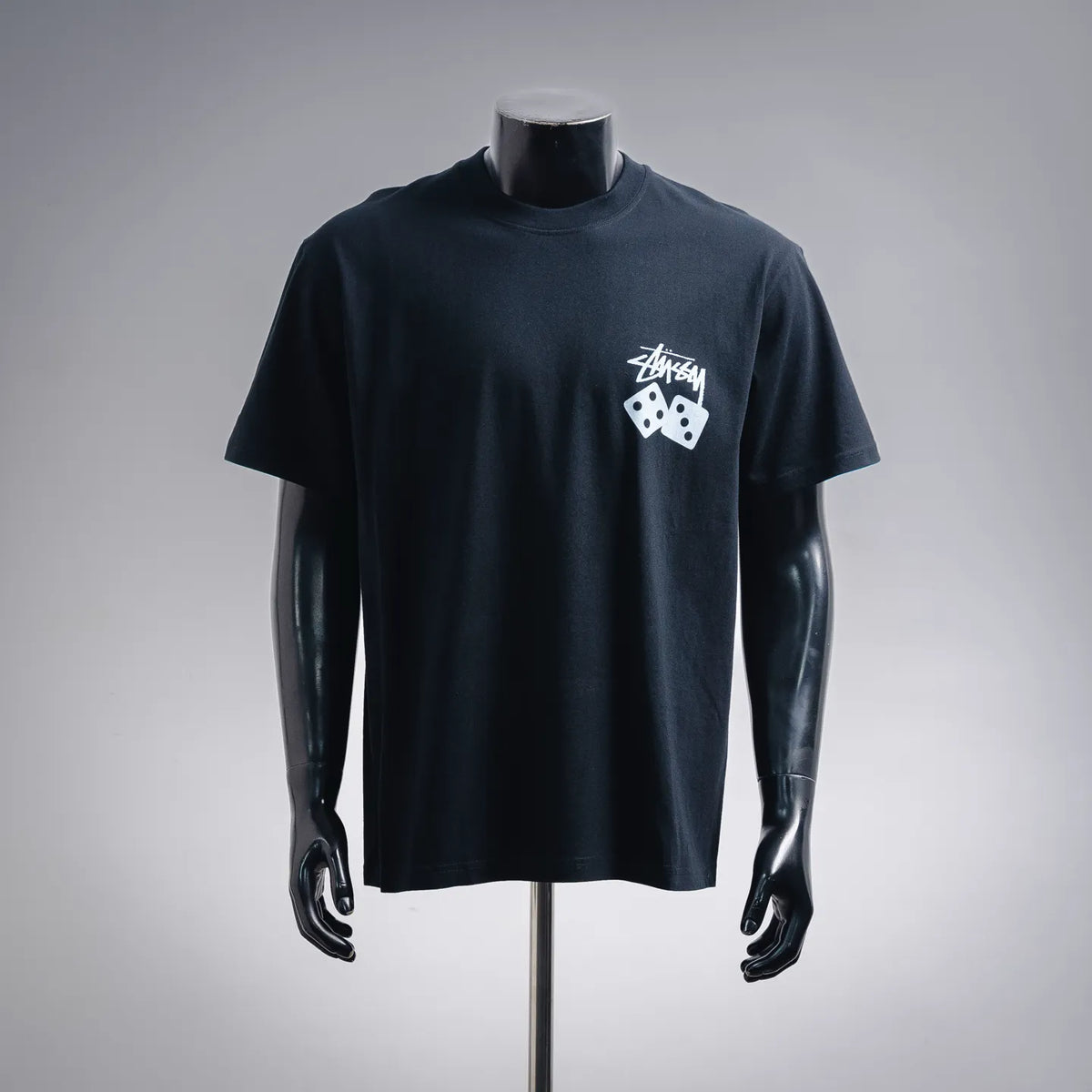 Black short-sleeve T-shirt with white Stussy graphic dice logo at chest