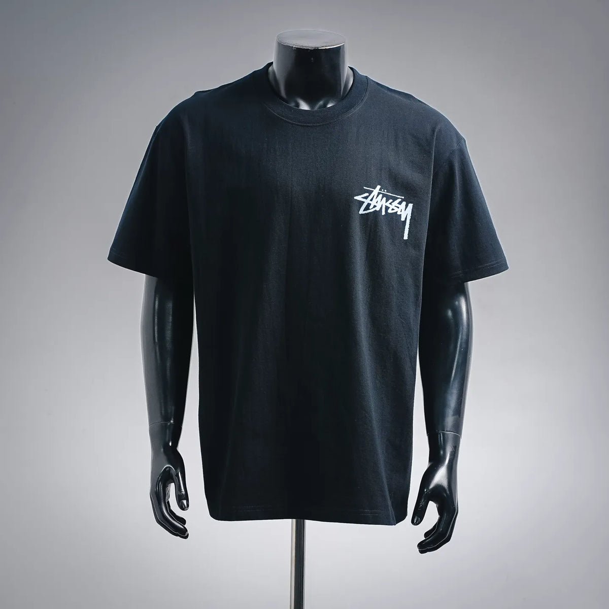 Black short-sleeve T-shirt with white Stussy logo on the chest.