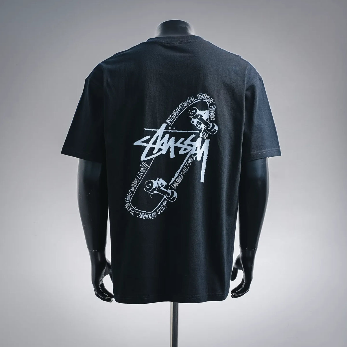 Black short-sleeve T-shirt with large white Stussy graphic on the back.
