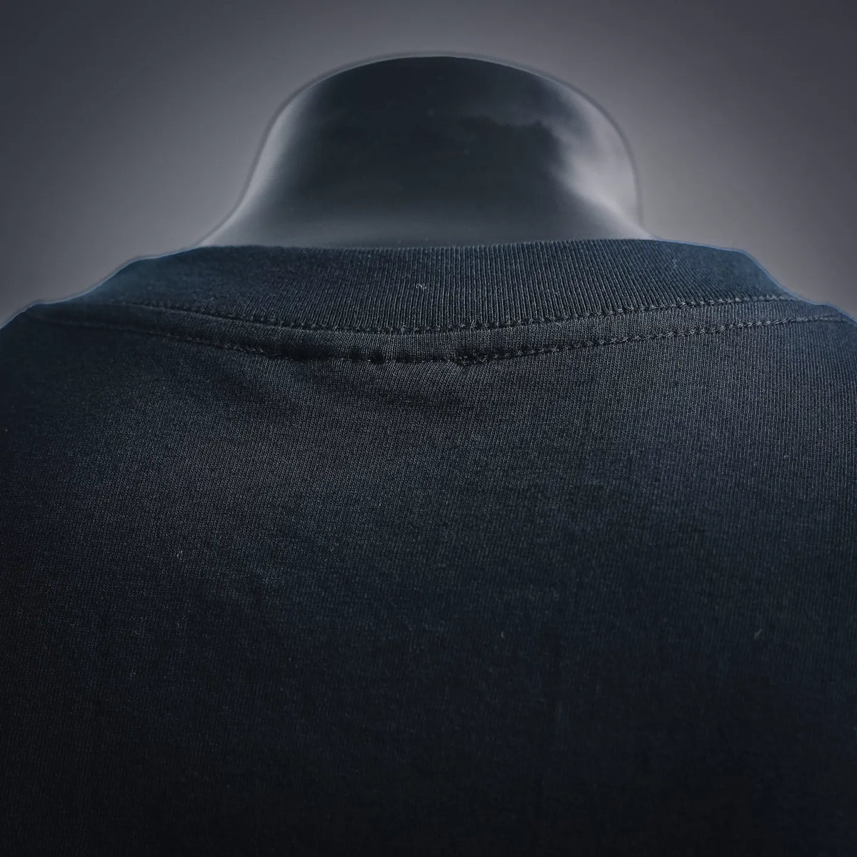 Black T-shirt collar seam close-up with ribbed crew neckline