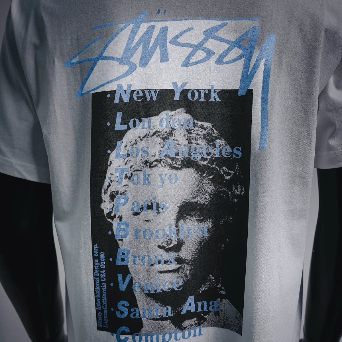 Stussy back print close-up with blue Stussy text and city names in black