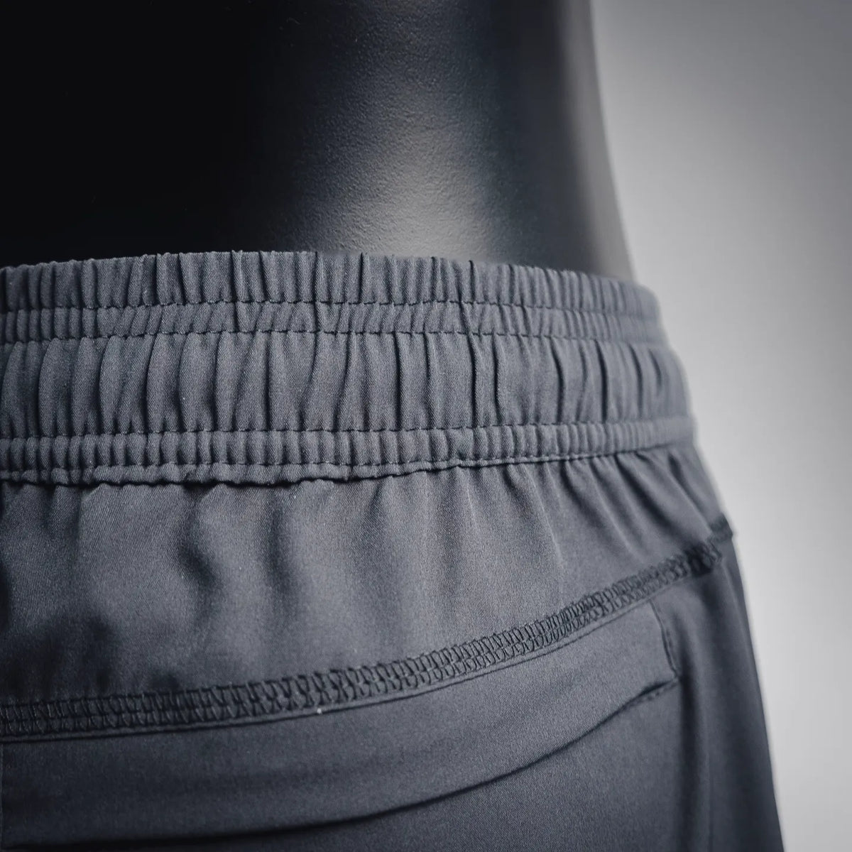 Dark gray shorts front close-up with elastic waistband and pocket seam